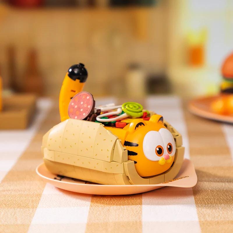 A toy resembling a cat is sitting on a plate, which is placed on a table.