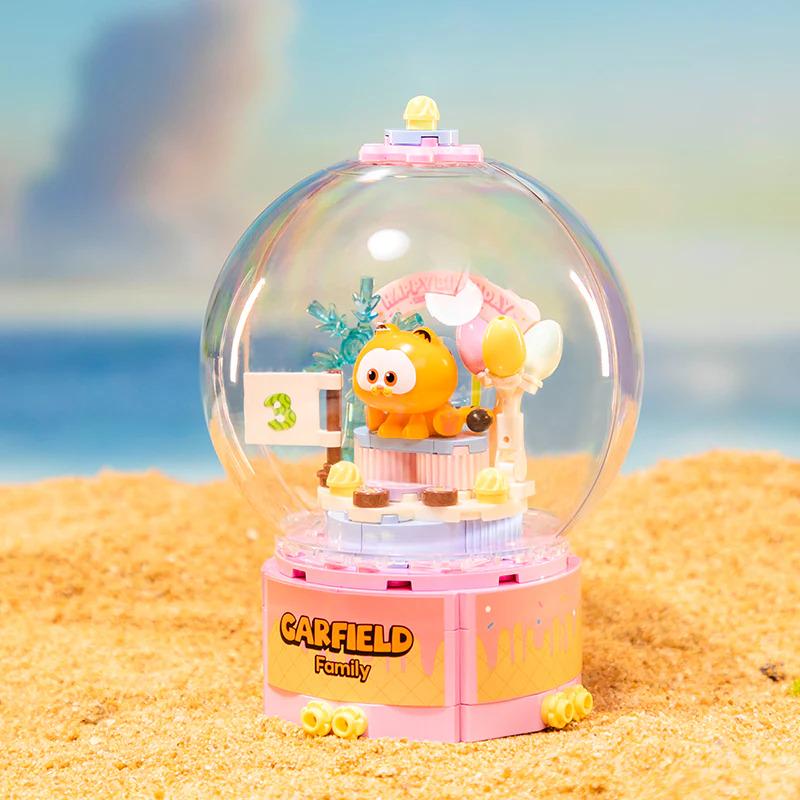 A pink and yellow LEGO set featuring a LEGO character resembling a cartoon dog or cat, with a clear dome-shaped base and various accessories inside.