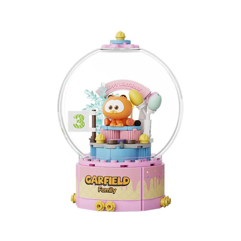 A colorful toy figurine of a character from the animated series Garfield, featuring a pink and blue base with a clear dome-shaped structure.