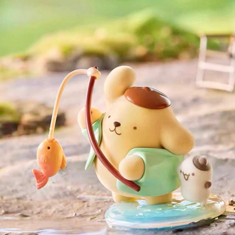 A small figurine of a yellow dog holding a fishing rod and a fish, with a smaller fish figurine next to it, set against a blurred natural background.