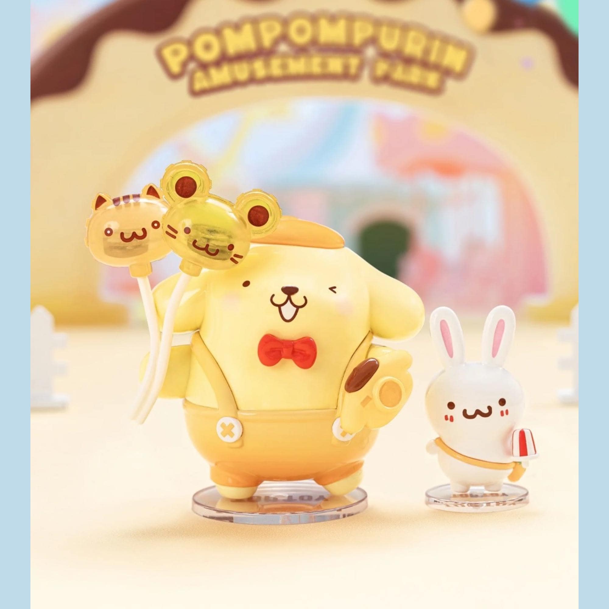 A figurine of a yellow dog wearing a red bow tie, holding a cat and a frog, standing next to a smaller white rabbit figurine.