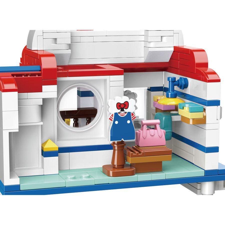 A colorful and detailed toy set depicting a shop or store, with various accessories and items such as a red and white building, a circular window, and a pink purse.
