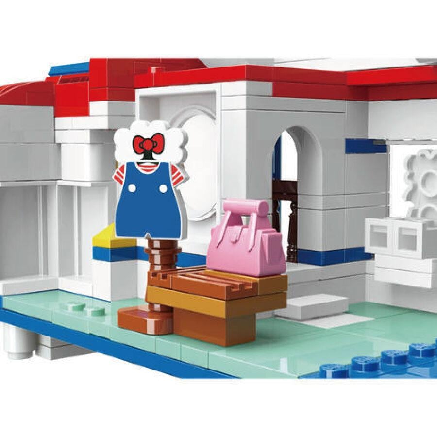 A colorful toy set depicting a dollhouse with a pink purse, a wooden bench, and a red and white striped dress.