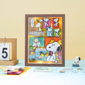 A framed collage of various Peanuts characters, including Snoopy, Woodstock, and other iconic figures, is displayed on a table.