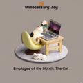 a cat sitting on a chair, with a laptop computer placed on a small wooden table next to it. The caption below the image reads "Employee of the Month: The Cat".