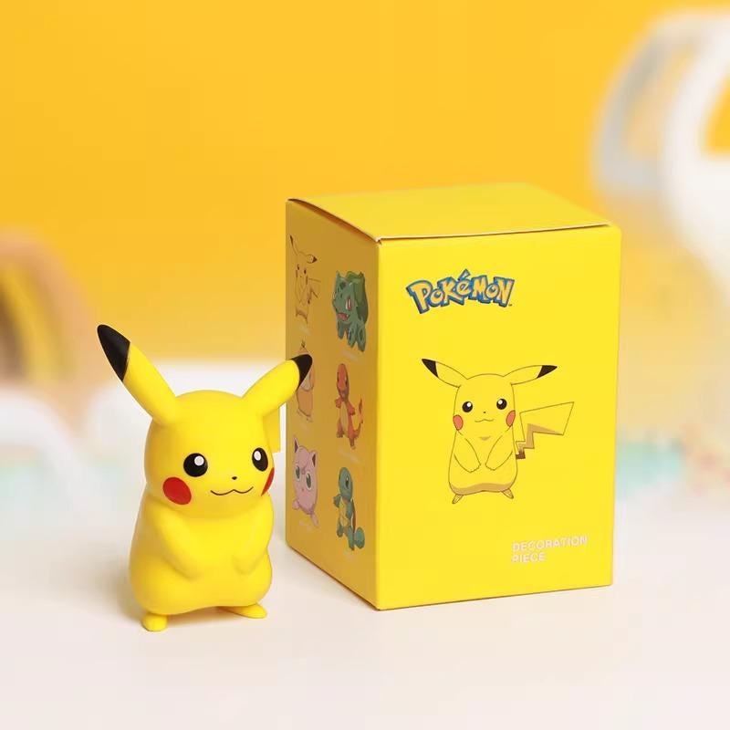 A yellow Pokemon-themed decoration piece, resembling Pikachu, is placed next to its packaging box.