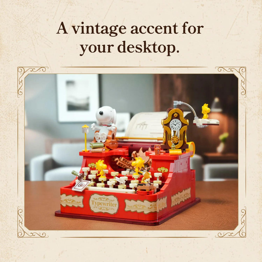 A vintage typewriter-inspired desktop accessory, featuring a red and gold color scheme, a clock, and various other decorative elements.