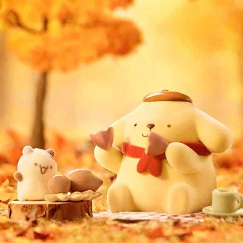 A small figurine of a dog sitting on a wooden stump, surrounded by autumn leaves, with another small figurine nearby.
