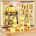 a collection of yellow, cartoon-like figurines, likely representing various animals or characters, displayed on a wooden surface.