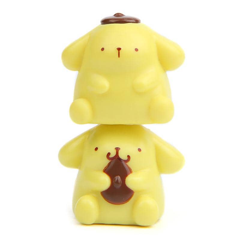 two yellow toy figurines, one sitting on top of the other, both with brown accents.