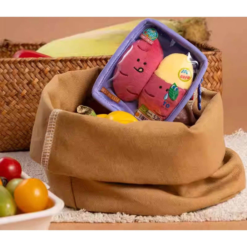 A brown woven basket containing a toy resembling a brain and a yellow toy, along with a bowl of fruit, including bananas and oranges.