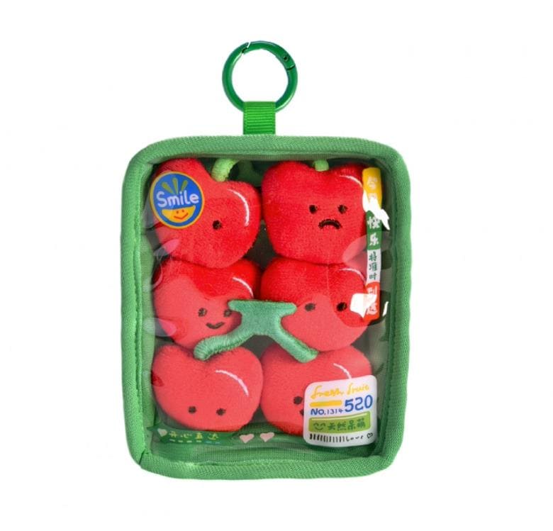 A package containing six red plush toys with faces, each with a different expression, displayed in a clear plastic container with a green handle.