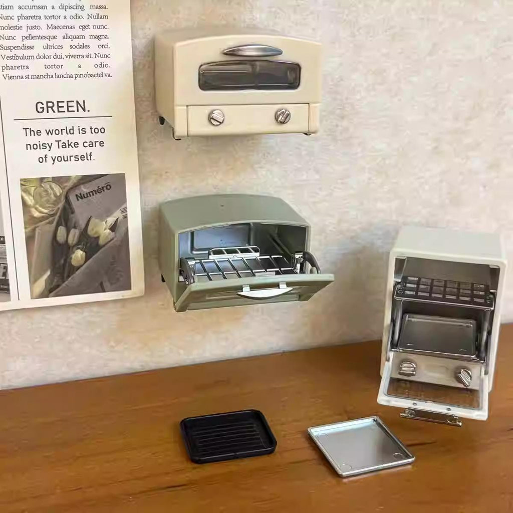 a collection of vintage kitchen appliances, including a toaster oven, a microwave, and a small oven, displayed on a wooden surface.