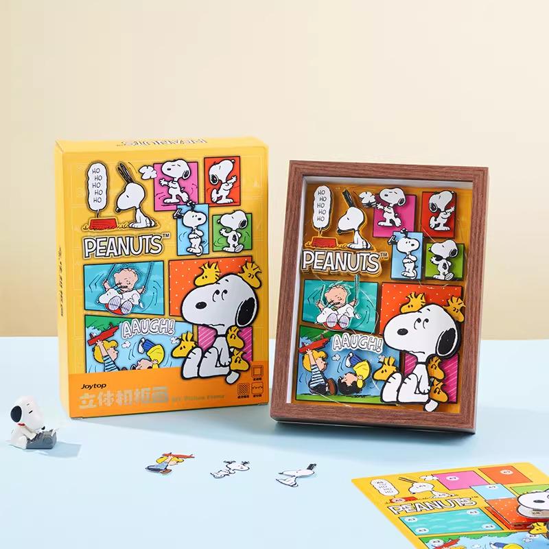 two framed pictures of the Peanuts characters, including Snoopy, Woodstock, and their friends, along with a puzzle box and some puzzle pieces.