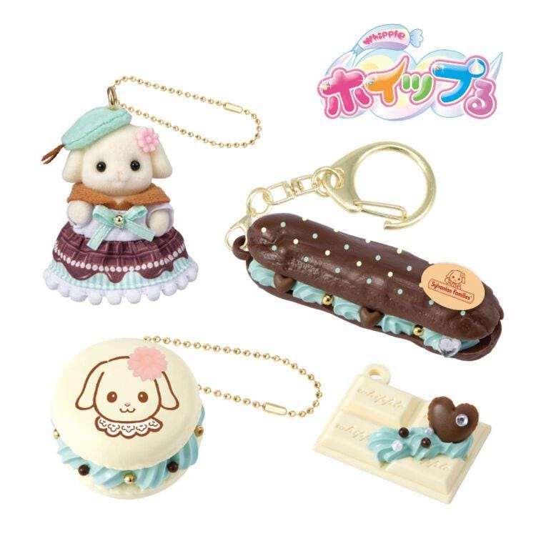a collection of small, cute, and colorful keychains and trinkets, including a doll, a chocolate pastry, and a heart-shaped chocolate treat.