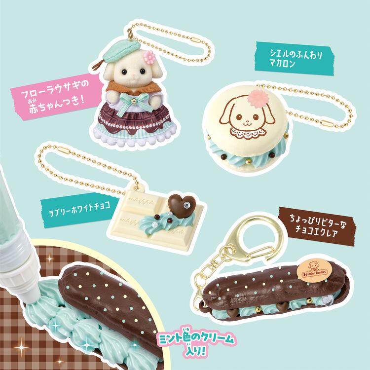 various keychains and trinkets, including a small dog figurine, a chocolate pastry, and a chocolate-covered chocolate bar. The keychains and trinkets are decorated with colorful designs and patterns, making them visually appealing and unique.