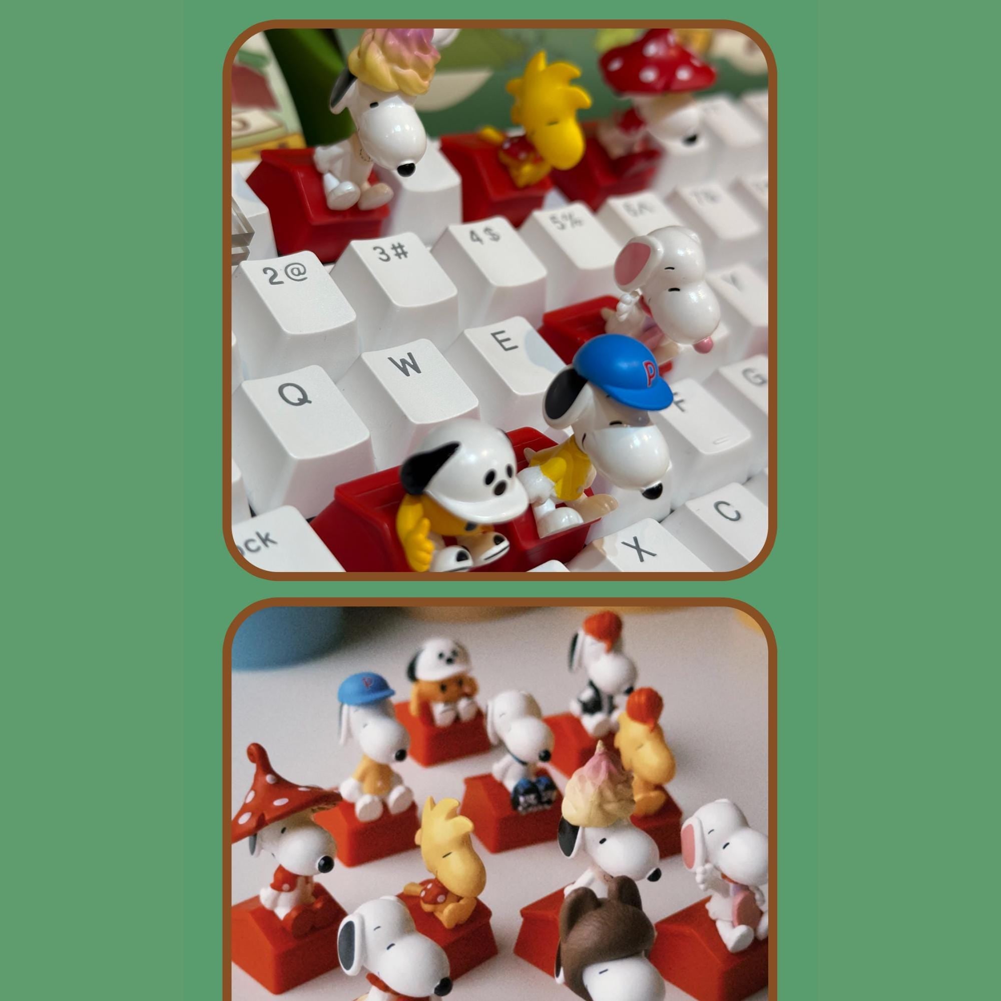 a collection of small toy figurines, including characters from the Peanuts comic strip, arranged on a computer keyboard.