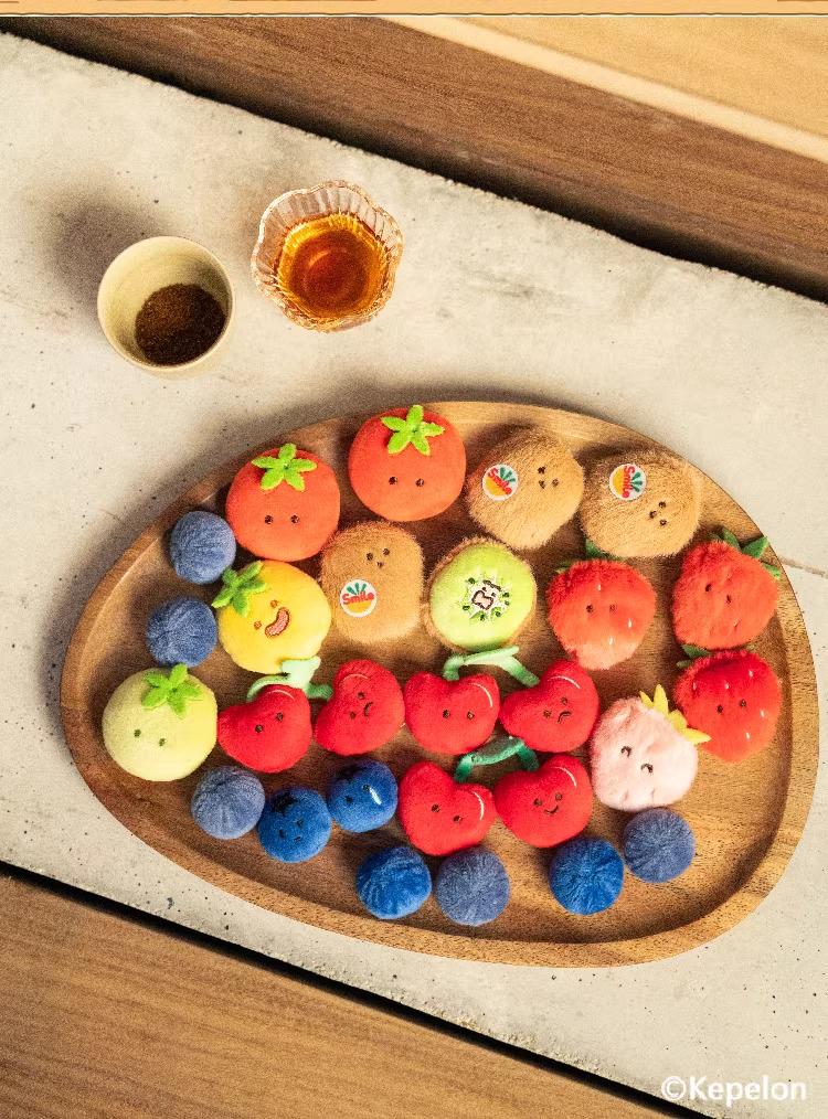 A wooden tray filled with various colorful fruit-shaped cookies and a small bowl of what appears to be honey or syrup.
