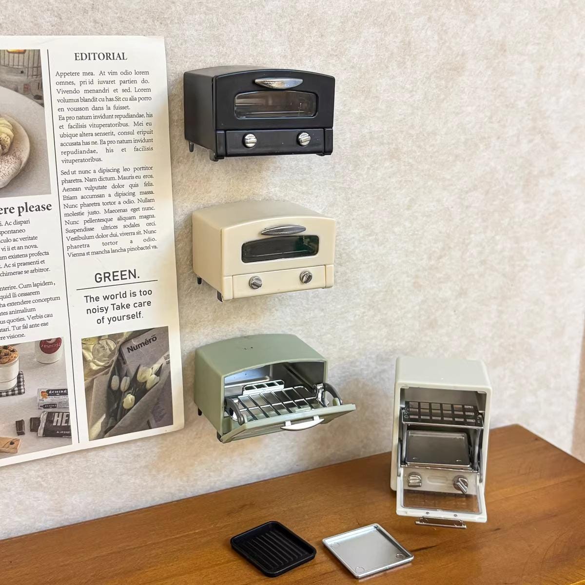 a collection of miniature toaster ovens displayed on a wooden surface, with a newspaper article visible in the background.