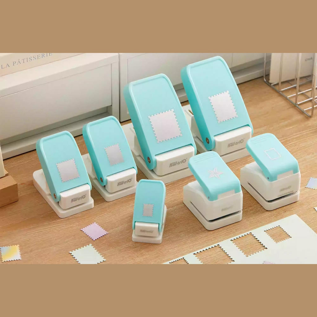 A collection of turquoise and white paper punch machines arranged on a wooden surface.