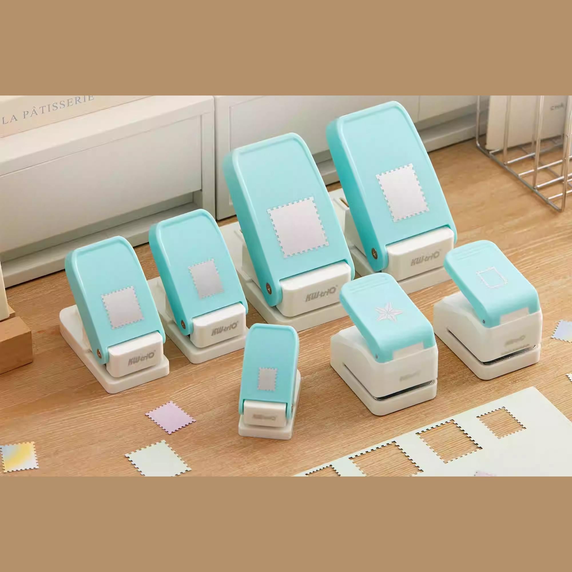 A collection of turquoise and white paper punch machines arranged on a wooden surface.