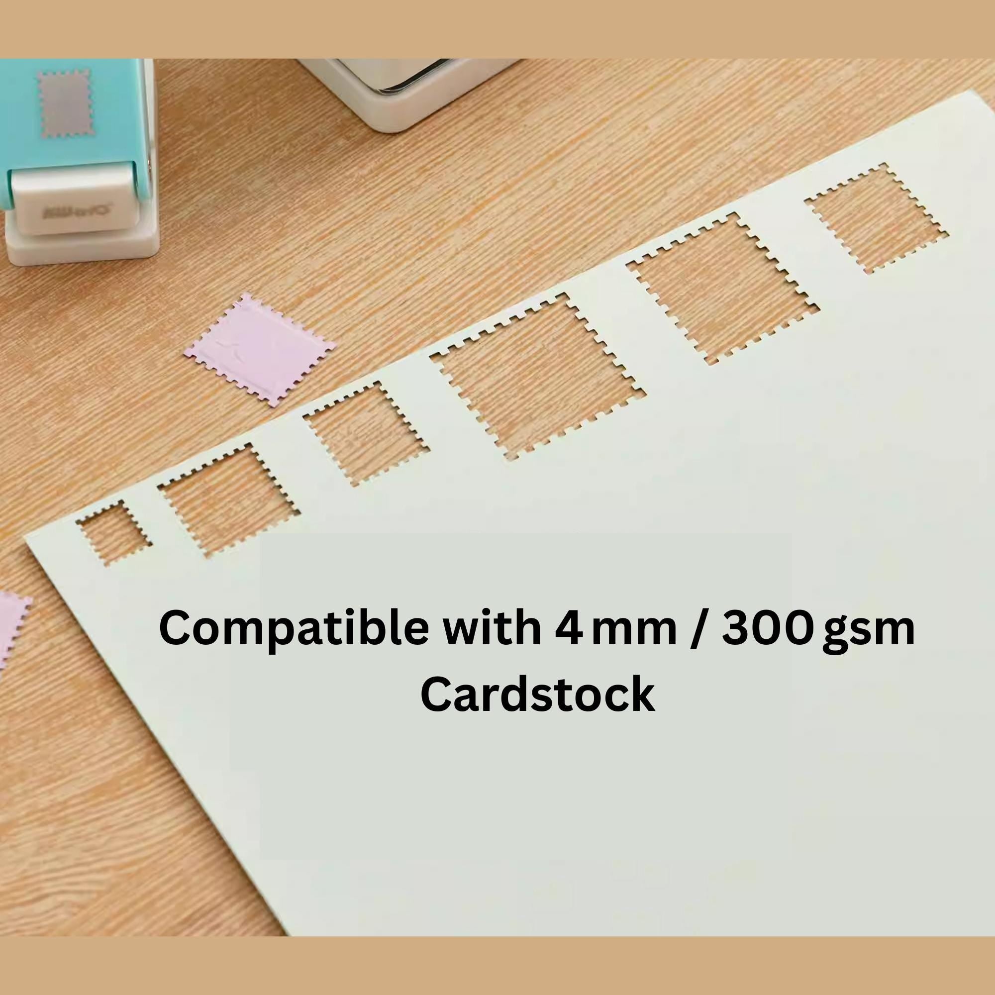 a white paper with several square cutouts, likely created using a hole punch or similar tool. The paper is placed on a wooden surface, and there are some additional cutouts visible in the background.