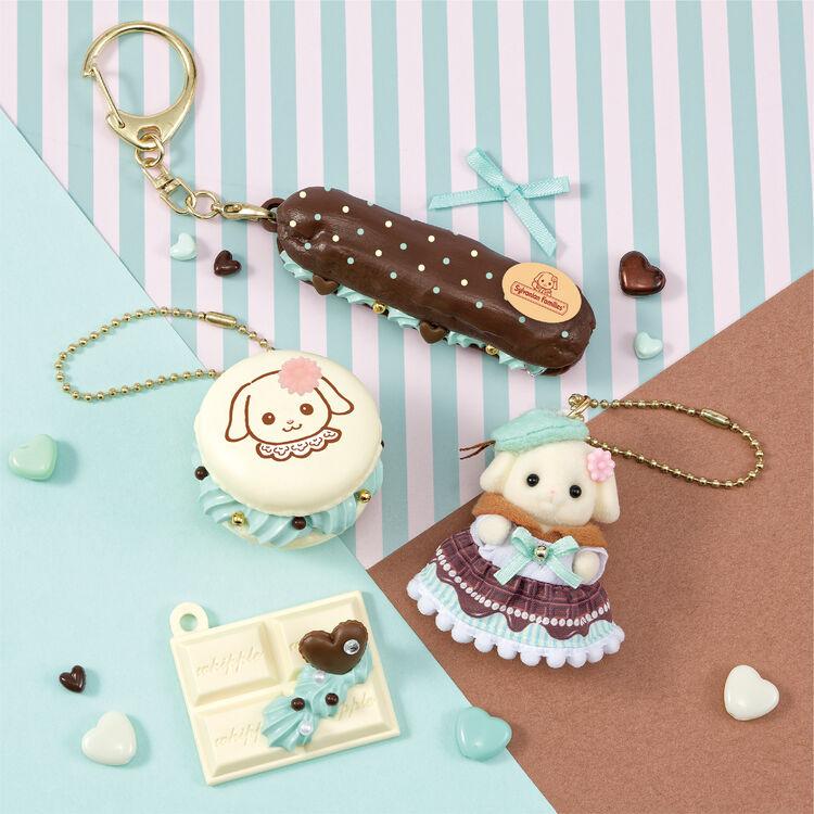 a collection of pastel-colored keychains and trinkets, including a chocolate-covered pastry, a small stuffed animal, and a keychain with a heart-shaped charm.