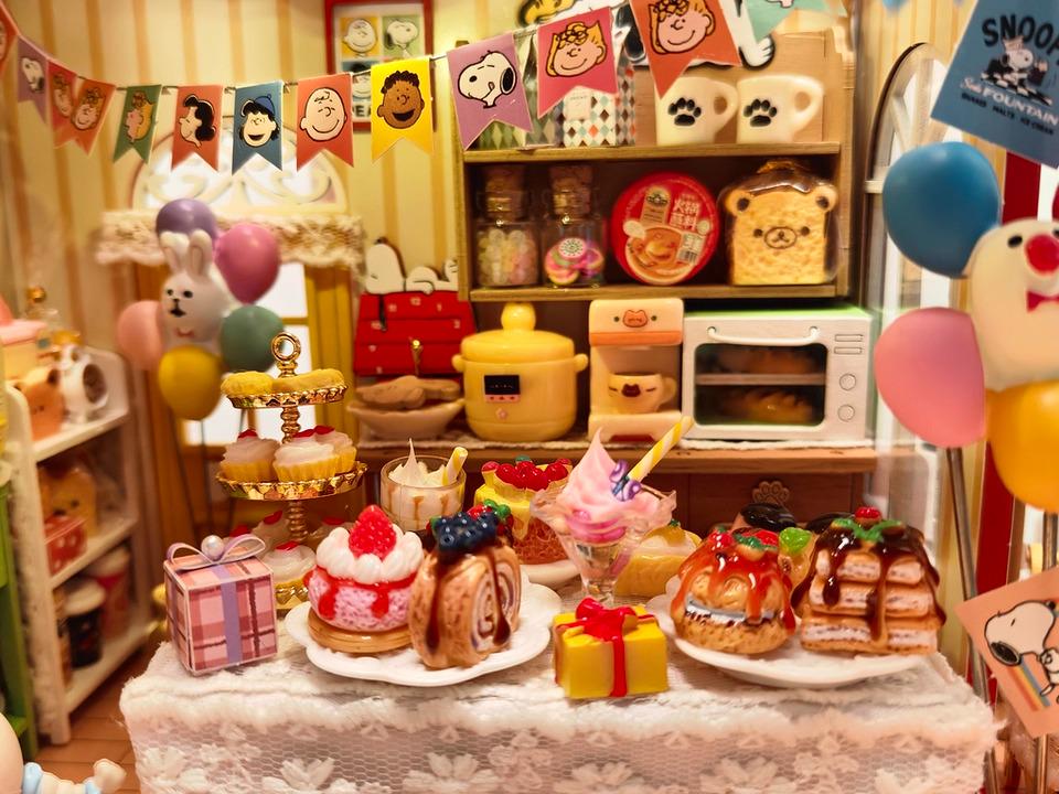 A miniature Peanuts-themed party with a table filled with various Peanuts-themed desserts, decorations, and other Peanuts-related items.