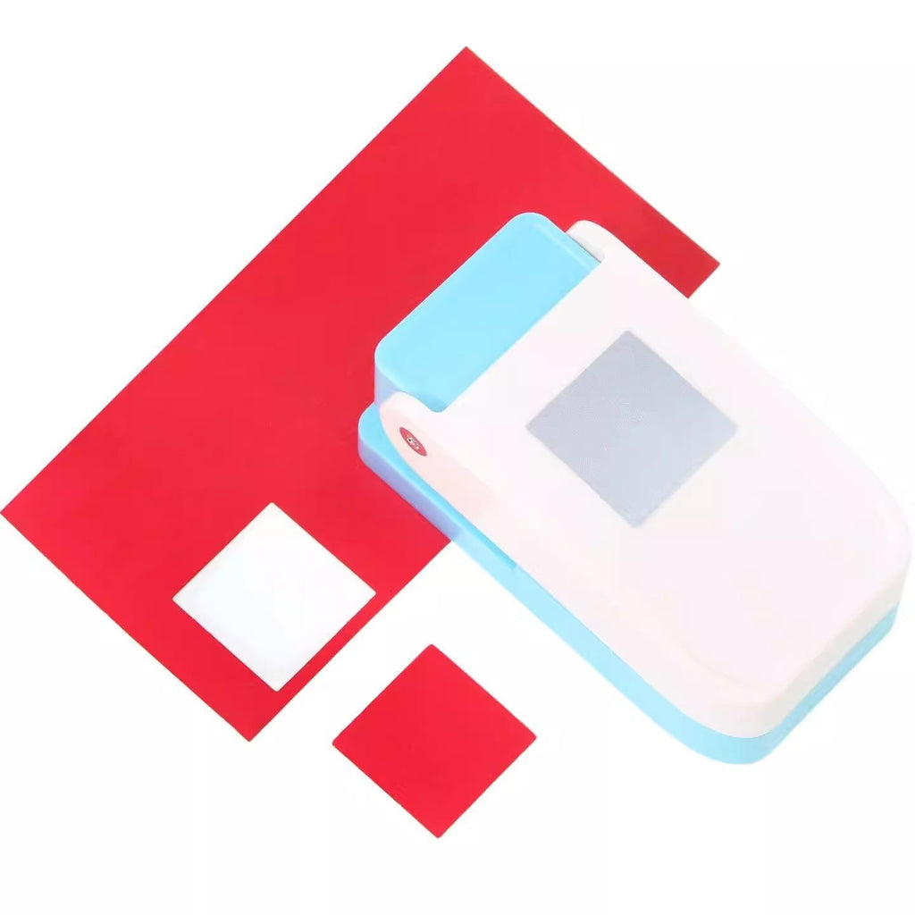 a red and white object, which appears to be a paper cutter or stapler, with a small white square on it.