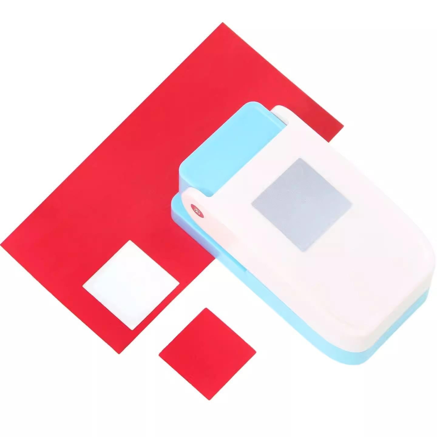 a red and white object, which appears to be a paper cutter or stapler, with a small white square on it.