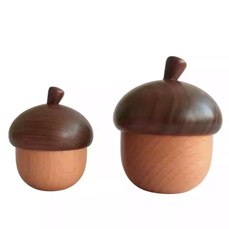 Two wooden acorn-shaped objects with brown caps are shown against a white background.