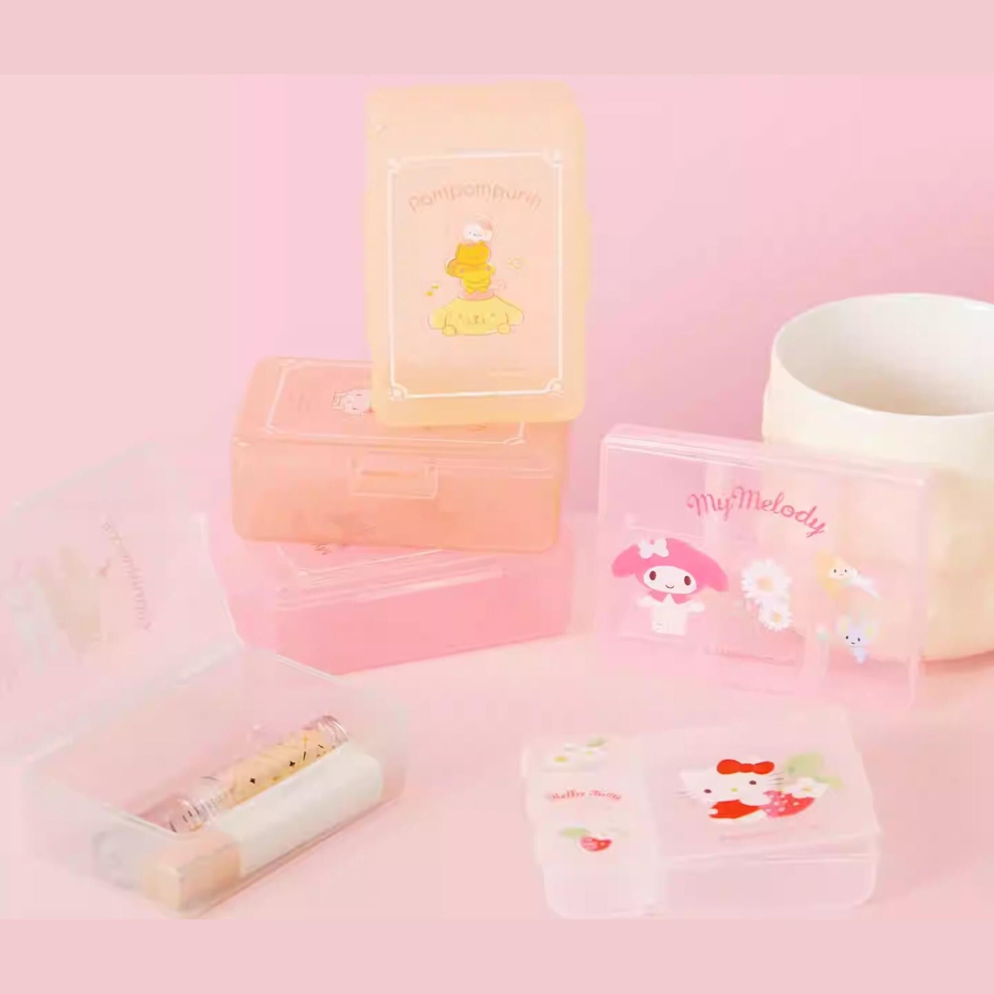 a collection of pink and white containers and a white mug, all adorned with cute cartoon character designs.