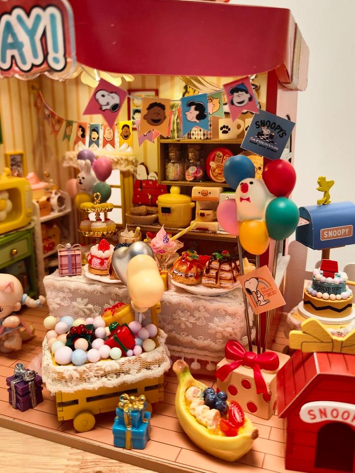 A colorful and whimsical miniature toy shop filled with various toys, decorations, and treats, including a Snoopy-themed section.