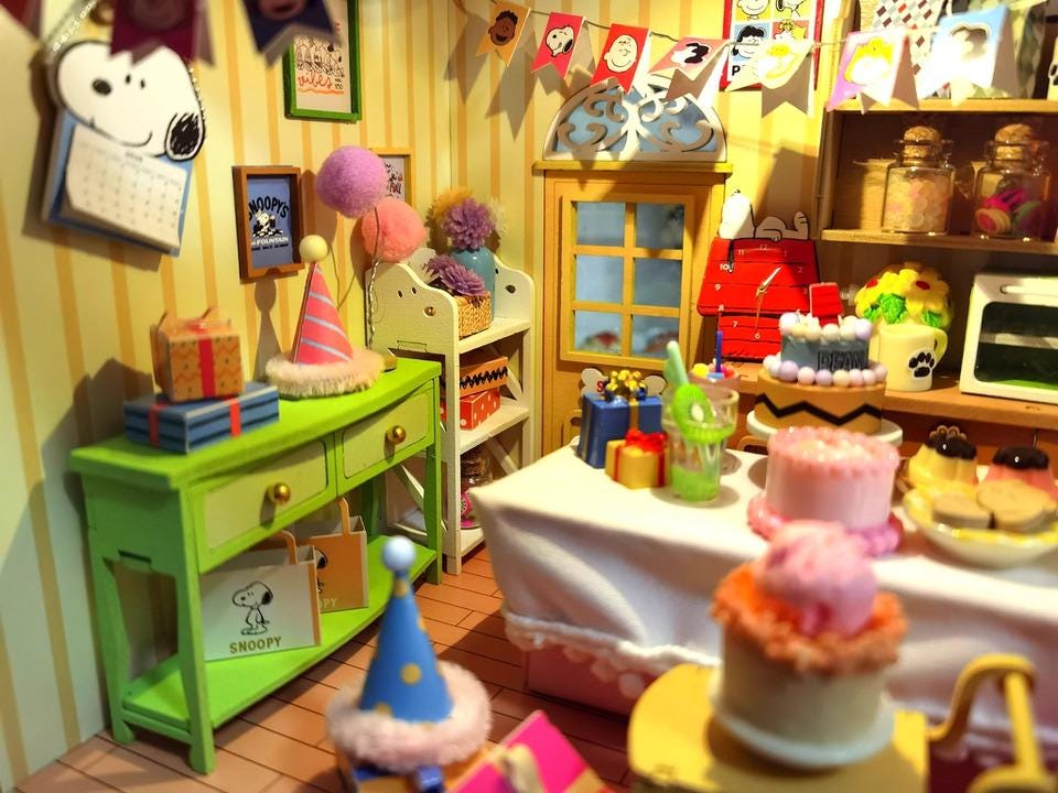 A colorful and whimsical miniature dollhouse filled with various party decorations, toys, and treats, creating a lively and festive atmosphere.