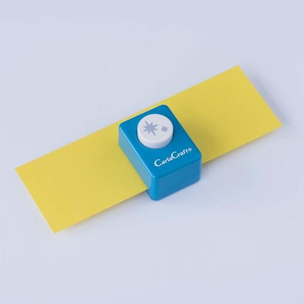 A blue and yellow paper punch with a star design on it, placed on a yellow piece of paper against a white background.