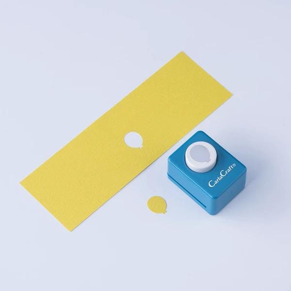 a yellow paper and a blue paper punch with a white button on it, both placed on a white background.