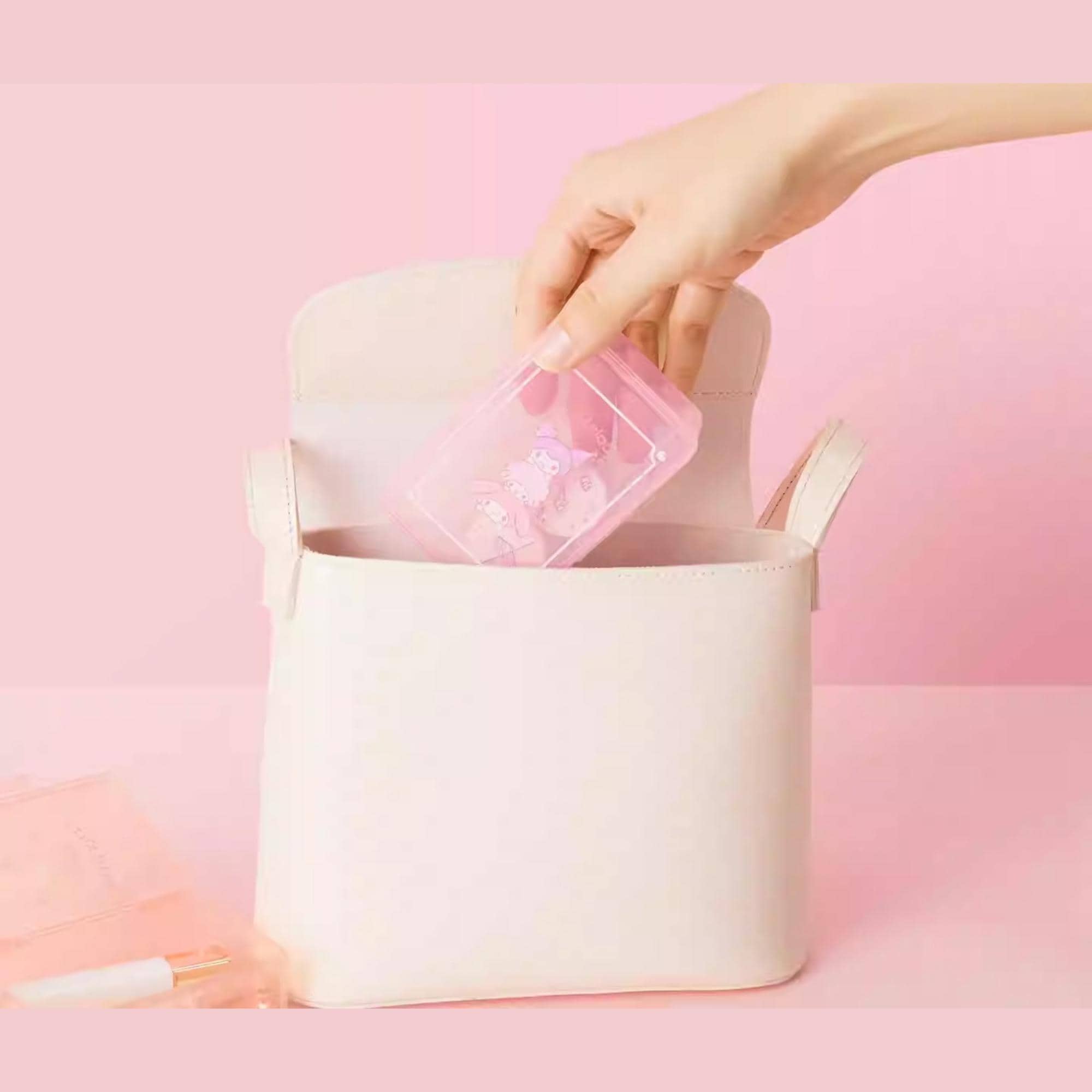 A hand is holding a pink object, which appears to be a small pink container or bag, out of a white purse or bag.