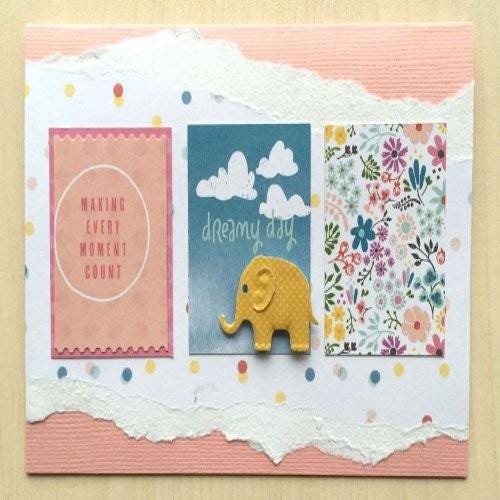 A handmade greeting card with a pink background, featuring a yellow elephant, a cloud, and a floral pattern.
