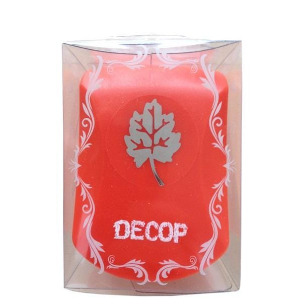 a red candle with a leaf design and the word "DECOP" written on it, placed inside a clear plastic container with a decorative border.