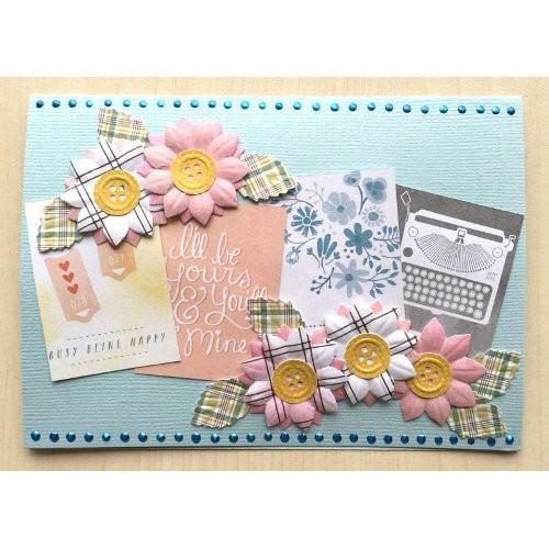 A handmade greeting card featuring various decorative elements such as flowers, typewriter, and text.
