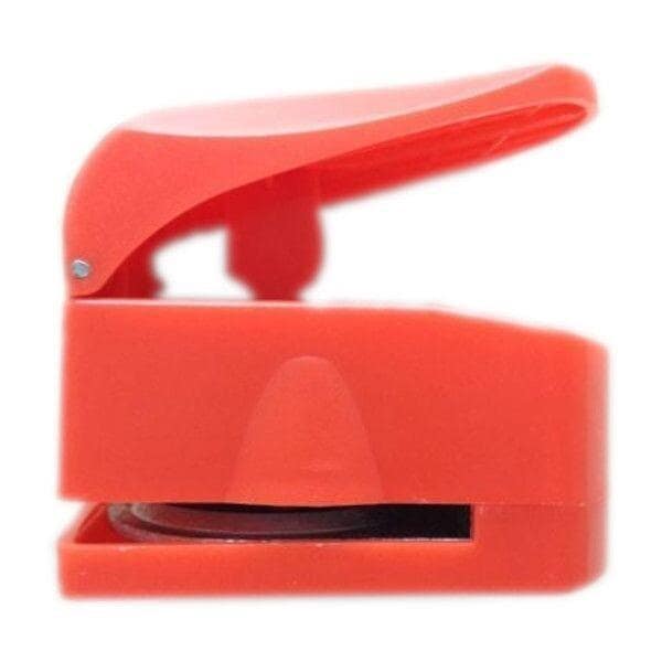 A red plastic stamp with an open lid, which is a common tool used for creating holes in paper or other materials.