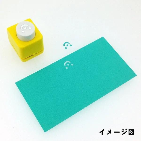 A yellow paper punch with a white circular button is shown next to a green rectangular sheet of paper on a white background.