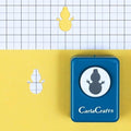 A blue hole puncher with a snowman design on it, placed on a yellow background.