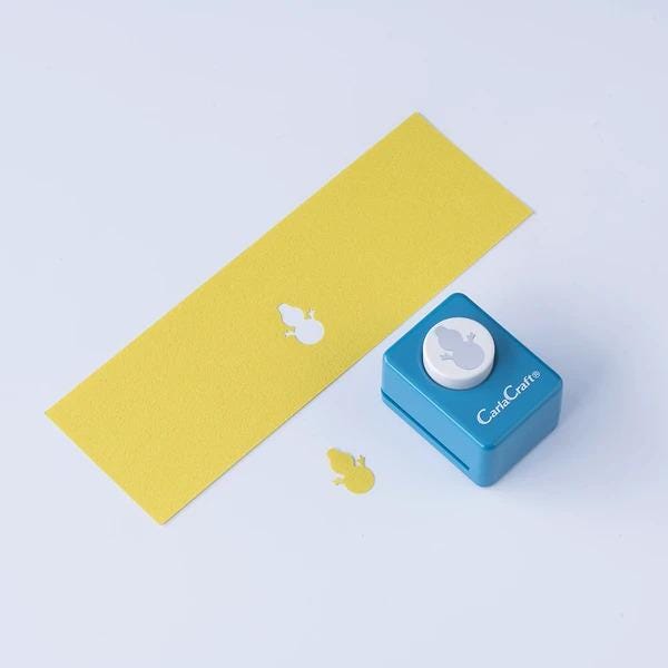 a yellow paper with a white hole punch and a blue push button cutter on a white background.