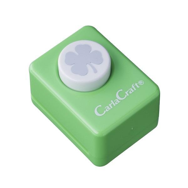 A green push button with a white clover symbol on it, which appears to be a craft or decorative item.