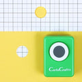 A green hole puncher is placed on a yellow background with a grid pattern.
