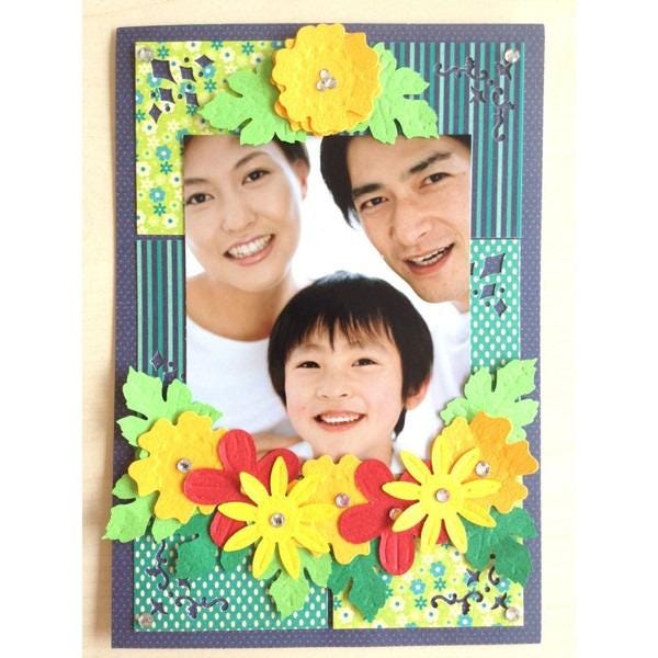 A family portrait of a woman, a man, and a young boy, all smiling and framed by a colorful floral border.