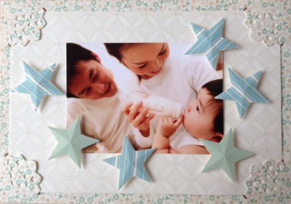 A family photo of a woman feeding a baby, surrounded by decorative stars and lace elements.