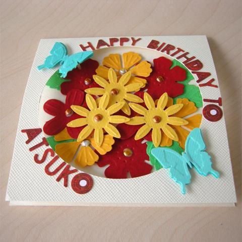 A handmade birthday card featuring a colorful arrangement of flowers and butterflies.