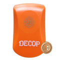 An orange object with the word "DECOP" written on it, along with a small gold button next to it.